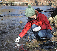 Erin Savage sampling water for testing at the Fields Creek slurry spill