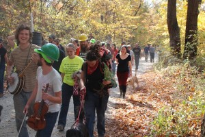 Activists marching through the forest, trees and instruments in hand. (Credit: Climate Ground Zero)