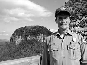 Matt Windsor, park superintendent of Pilot Mountain State Park, stands at Little Pinnacle Overlook, with the Big Pinnacle rising in the background.