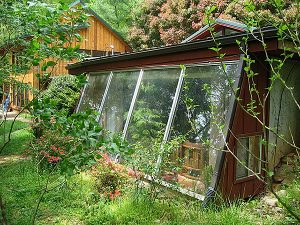 A window into energy efficiency: the south-facing greenhouse soaks up the sun while the earthen sidewalls provide insulation. Photo by Patrick Ironwood
