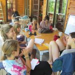 Interns at the New Beginnings camp meet in the afternoons to plan for upcoming days and discuss how to resolve conflicts between campers. Photo by Kimber Ray