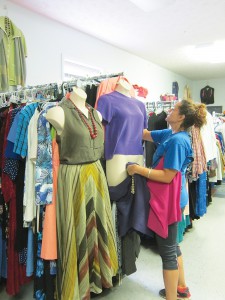 A volunteer at the New Opportunity School's clothing boutique arranges a mannequin display. The boutique supplies the school's graduates with free business appropriate outfits, and also employs graduates from the program. Photo by Molly Moore