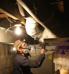Will Hadaway, owner of HomEfficient, seals Vance Woodie's basement ducts with mastic.