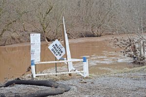 Signs at a gravel lot alongside Middle Island Creek in Doddridge County, W. Va., make it clear that only water trucks from drilling company EQT are permitted to withdraw water. In West Virginia, about 5 million gallons of fluid are used for each fractured well, and 80 percent or more of that water comes directly from streams and rivers. Photo by Molly Moore. 