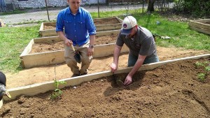 Veteran Logan Nance, director of operations at Growing Warriors, plants in a raised bed with a community member. Photo courtesy of Growing Warriors 