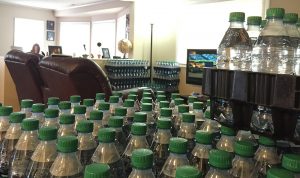 Bottles of water sit in stacks in Amy Brown’s living room. She is now familiar with how many bottles are needed for each family meal — boiling spaghetti takes four, while only two are needed for rice. 