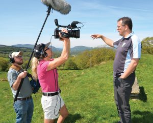 Filmmaker Tom Hansell and camera person Suzanne Clouseau interview Geraint Lewis near Abercraf, Wales. The company Lewis started, Call of the Wild, has repurposed an old farm and created a leadership development center. Photo by Mair Francis
