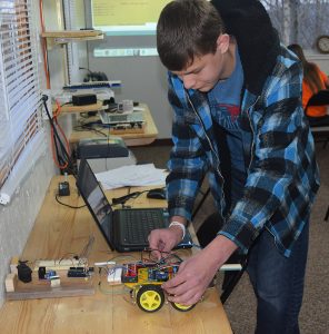 Elijah Kiser adjusts the robotic car at the Clintwood Learning Co-op.