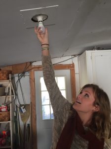 Volunteer Kaytlin Hester-Newnam installs an energy efficient LED light bulb. Photo: Ridge Graham