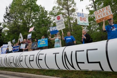 people stand with "no pipelines" signs