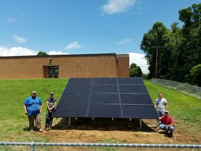 Crew members and completed solar installation.