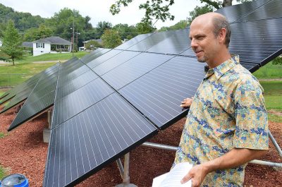 A man stands with solar panels