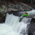 kayaker paddles over a ten foot waterfall