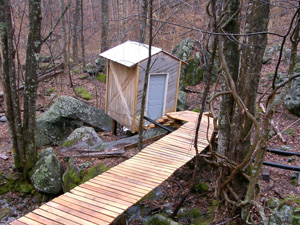 A deck leads to a shed housing a turbine and generator of Richard Cobb's microhydro system. Photo by Richard Cobb.
