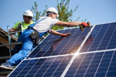 two men install solar panels 