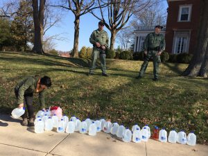 As security looks on, free water is distributed on March 14 in front of the Governor’s Mansion lawn in Charleston, W.Va. Residents and grassroots organization Mountain Justice coordinated the event as part of ongoing efforts to call for increased support of West Virginians still impacted by the chemical spill. Photo by Joe Solomon
