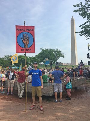 Man stands with protest sign at Washington, D.C. climate march