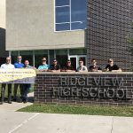 Members of solar workgroup stand outside a high school