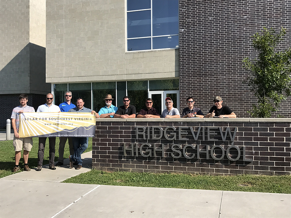 Members of solar workgroup stand outside a high school