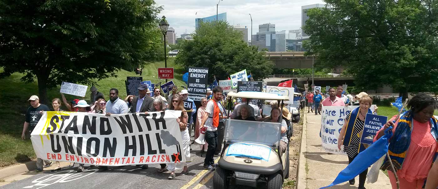 A photo of residents marching in Richmond with a Stand with Union Hill banner to protest the pipeline. Photo by Cat McCue
