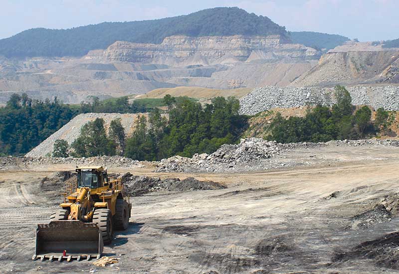 Photo of a bulldozer sitting on the barren landscape of a mountaintop removal coal mine in Southwest Virginia