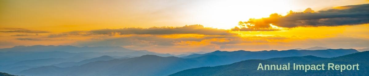Header image of a sunset lingering behind mountains with the words Annual Impact Report on top