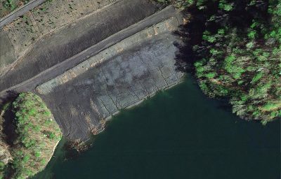 This aerial satellite photo looks down on a fissured earthen dam.