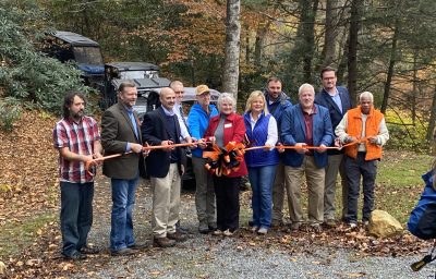 A group of locals and officials celebrate the opening of new Dante recreation area with a ribbon cutting ceremony.