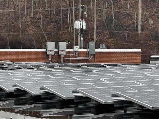Solar panels cover the roof of a brick building.