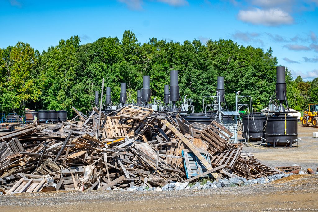 A pile of wood waste sits in the center of the photo.