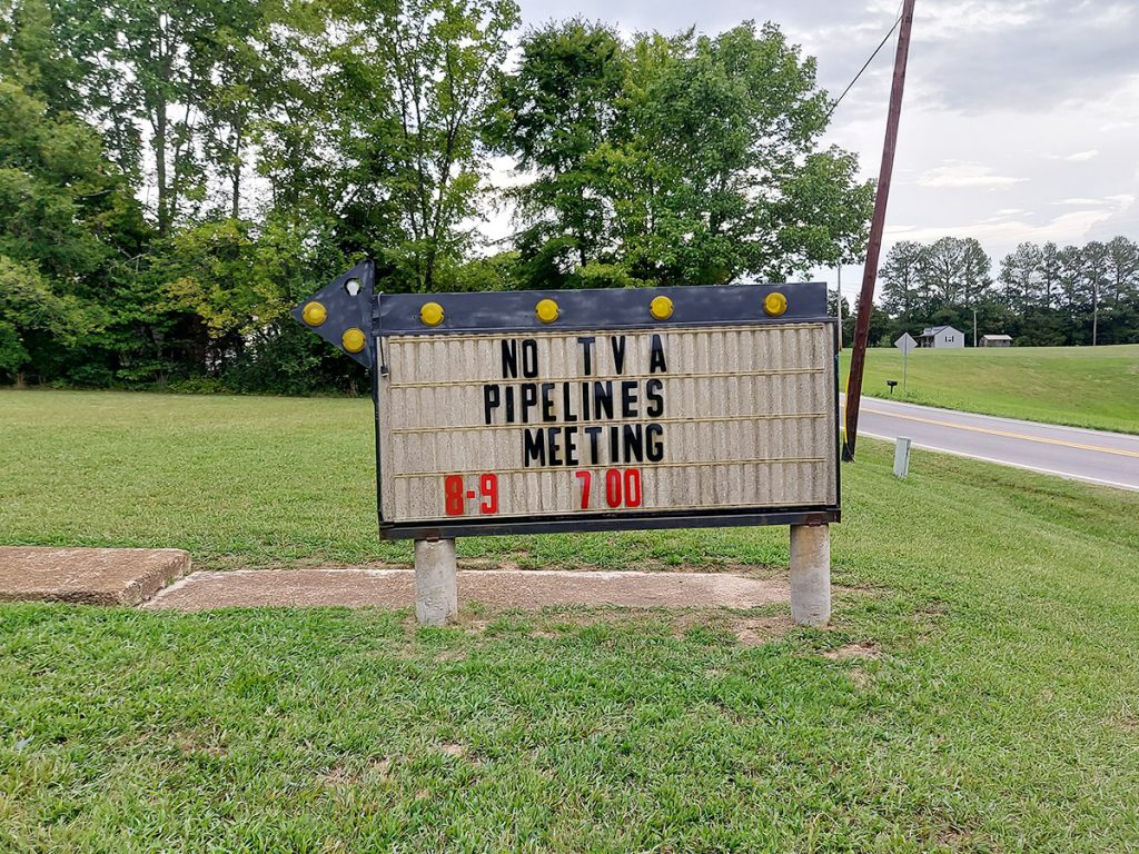 A sign advertises a No Pipelines meeting.