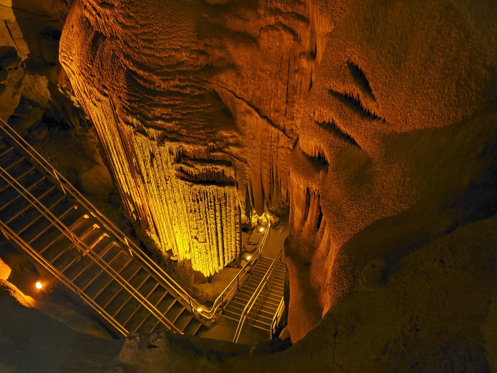 A deep cavern is illuminated, revealing unique rock formations.