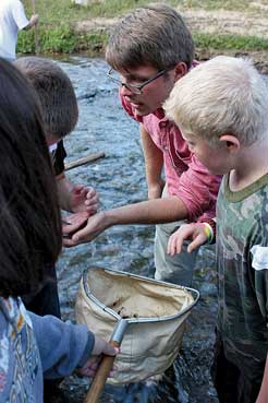 Byron Hamstead, a U.S. Fish & Wildlife Service intern, helps students in another county identify stream insects during a morning of outdoor education activities.  The types of insects in a river can be a useful indicator of water quality. Photos by Gary Peeples/USFWS