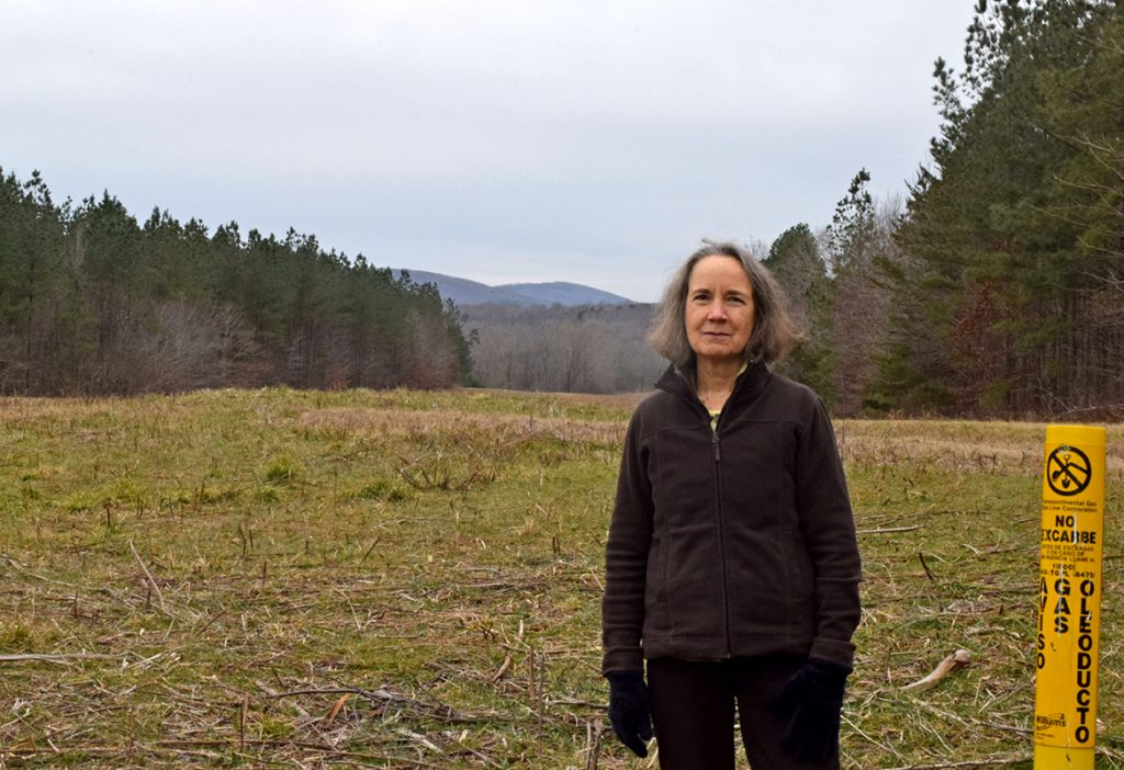 woman next to pipeline marker