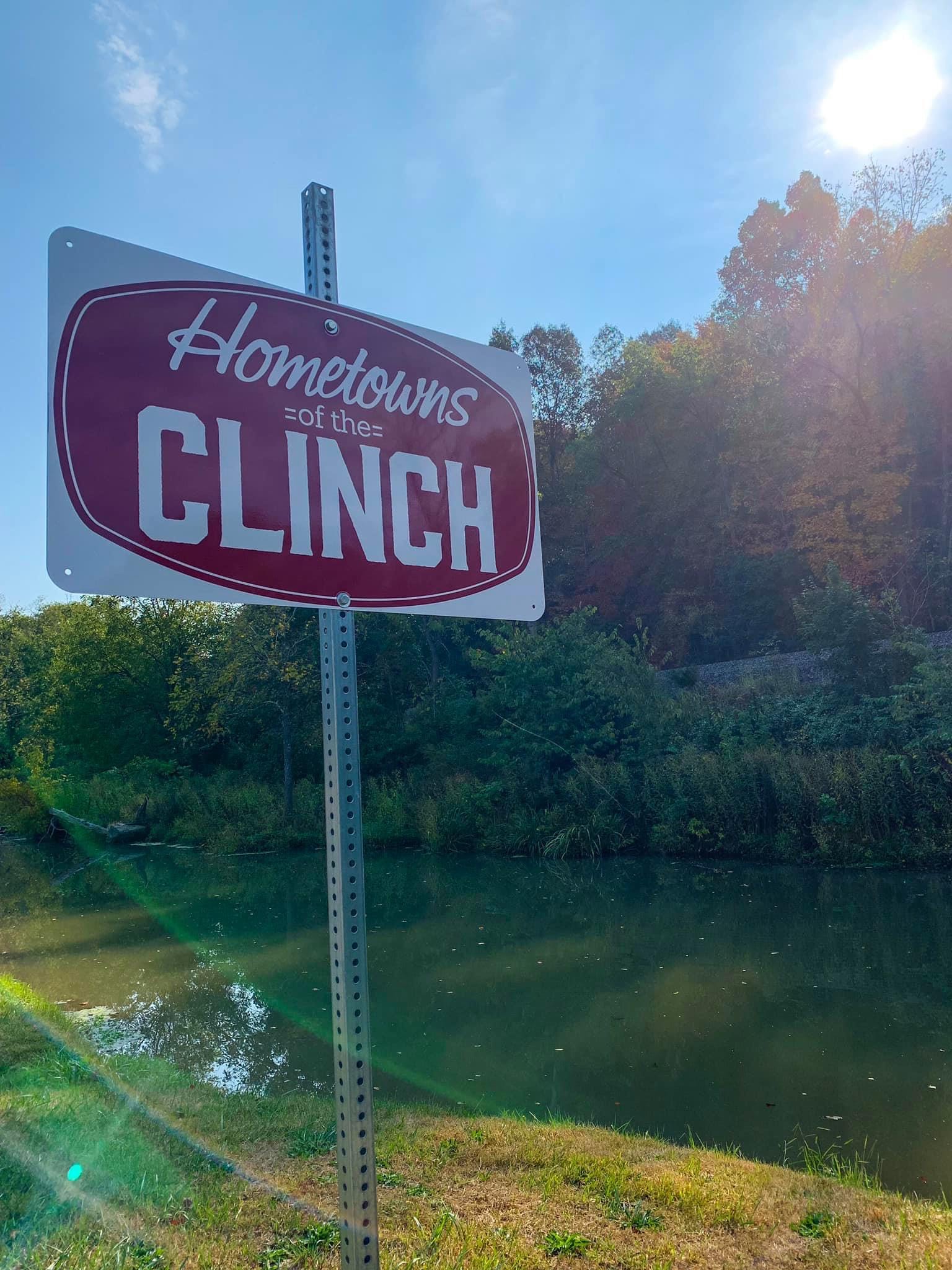 A sign beside the river reads "Hometowns on the Clinch"