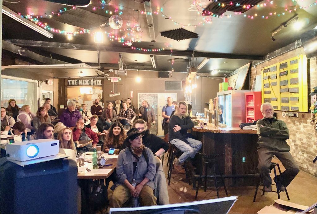 Several dozen men and women gather in a brewery to watch a presentation about the Ridgeline Pipeline Expansion project in Middle Tennessee.