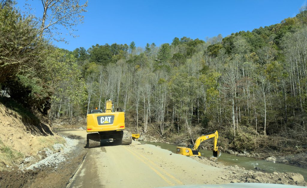 heavy equipment operators work on restoring the Cane River and damaged riverbank and road in Yancey County, N.C.