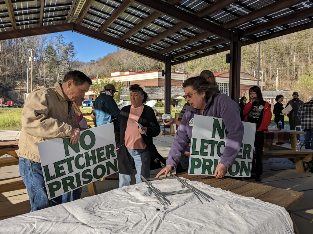 Opponents of FCI/FPC Letcher distribute yard signs at an event hosted by Concerned Letcher Countians in March. Photo by Willie Dodson.