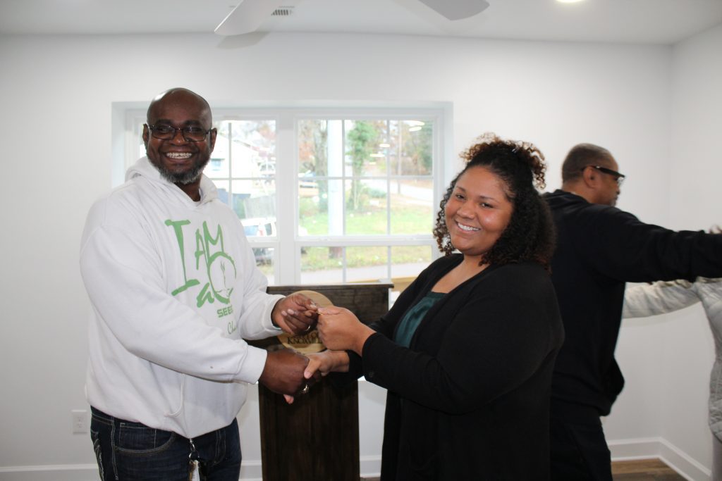 At a ribbon-cutting ceremony, SEEED’s CEO and Founder Stan Johnson hands over keys to the homeowner of the organization’s second energy-efficient home on Fern Street in Knoxville, Tenn. Photo courtesy of SEEED.