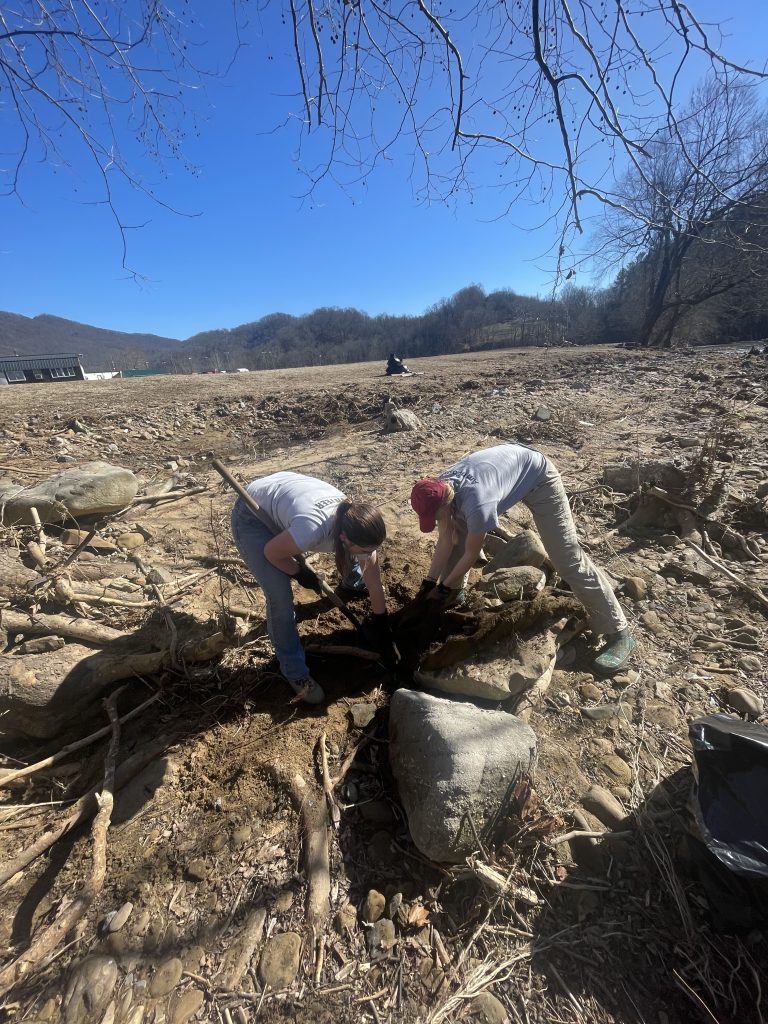 Volunteers clean up debris at Leeman Field following the 2025 flood.  