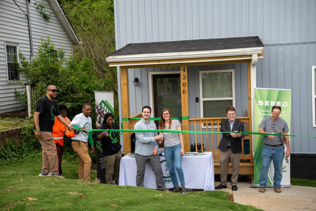 Homeowners Shawn O'Brien and Nicole Yacura cut the ribbon for their net-zero solar home with representatives from SEEED, ORNL and other partners. Photo by Abby Hassler.