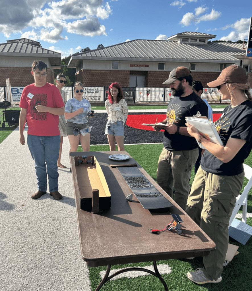 Andie Waugh and Jared Ring of Appalachian Voices oversee the student solar robot building competition. Photo by Rance Garrison.