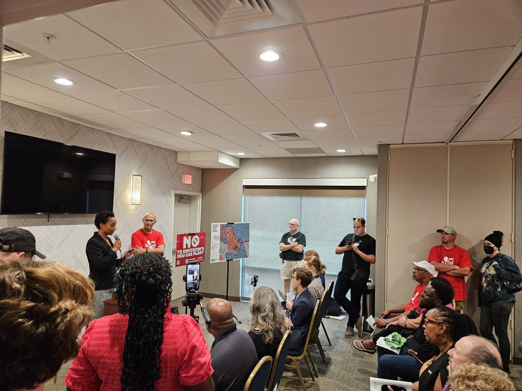 Group of people in red shirts talking at a press conference