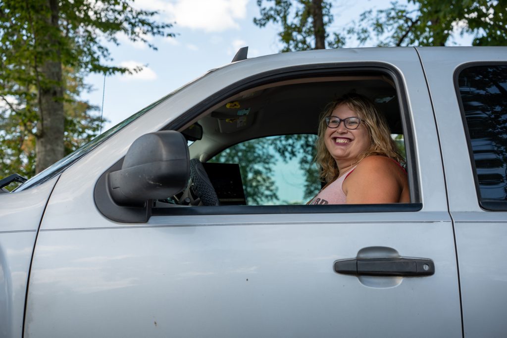 Photo of woman smiling and driving a truck