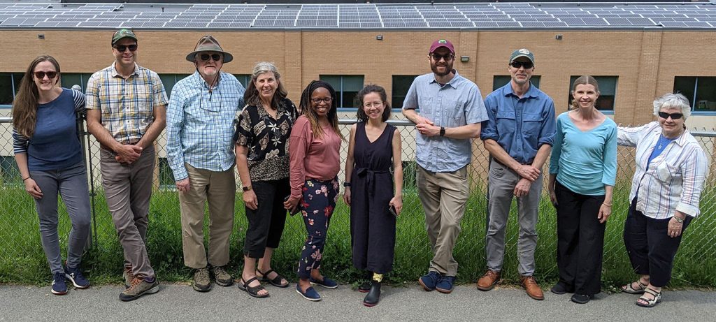 Appalachian Voices Board of Directors members and staff stand in front of a solar installation on an elementary school in Wise, Virginia, during a site visit.