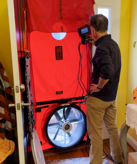 Andrew from Viridiant performs a blower door test to measure how airtight the author's home is.