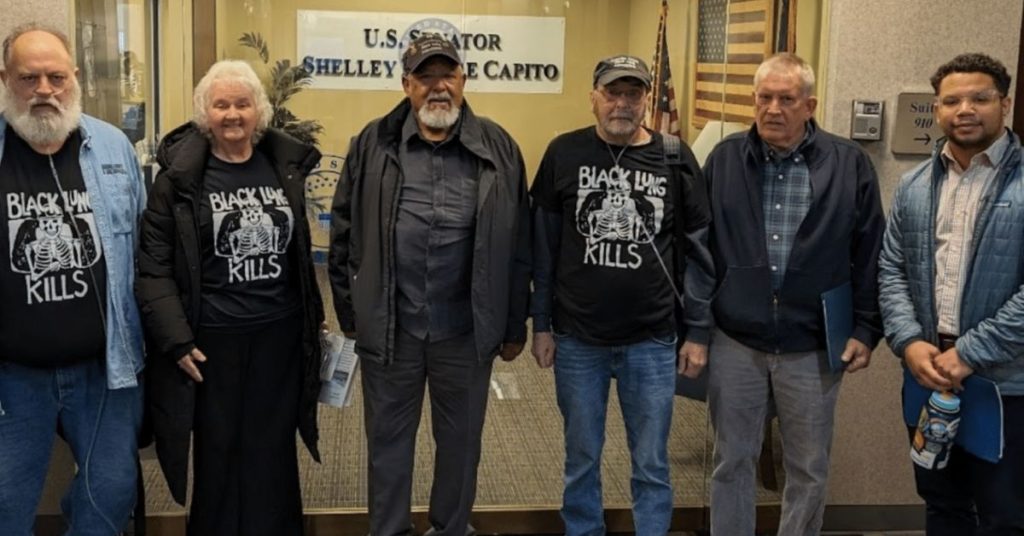 A group of Black Lung Association members stand in front of Shelley Moore Capito's office.