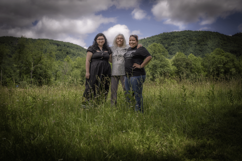 Appalachian Rekindling Project Co-Executive Directors, Tiffany Pyette and Taysha DeVaughn, stand on their Eastern Kentucky property with Jane Branham, who donated some family land to ARP. Photo by Anna Mullins