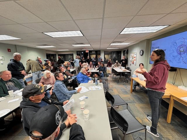 A woman speaks to people assembled at a library in Shawsville, Virginia about the MVP Boost project