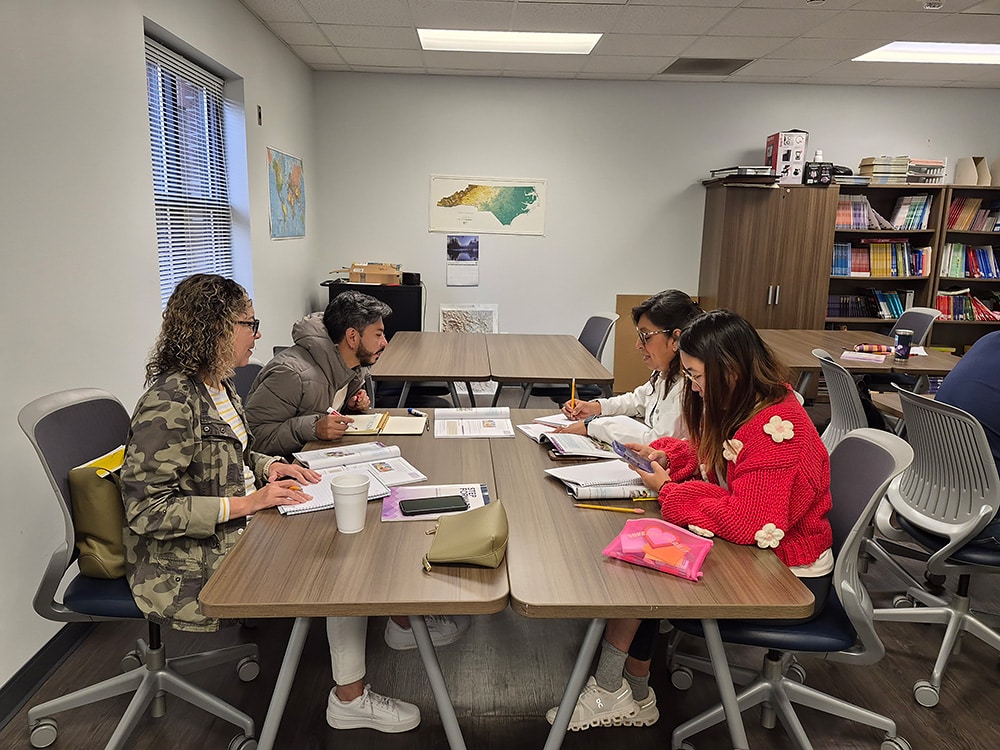 English language learners in Appalachia sit around a table doing their lesson